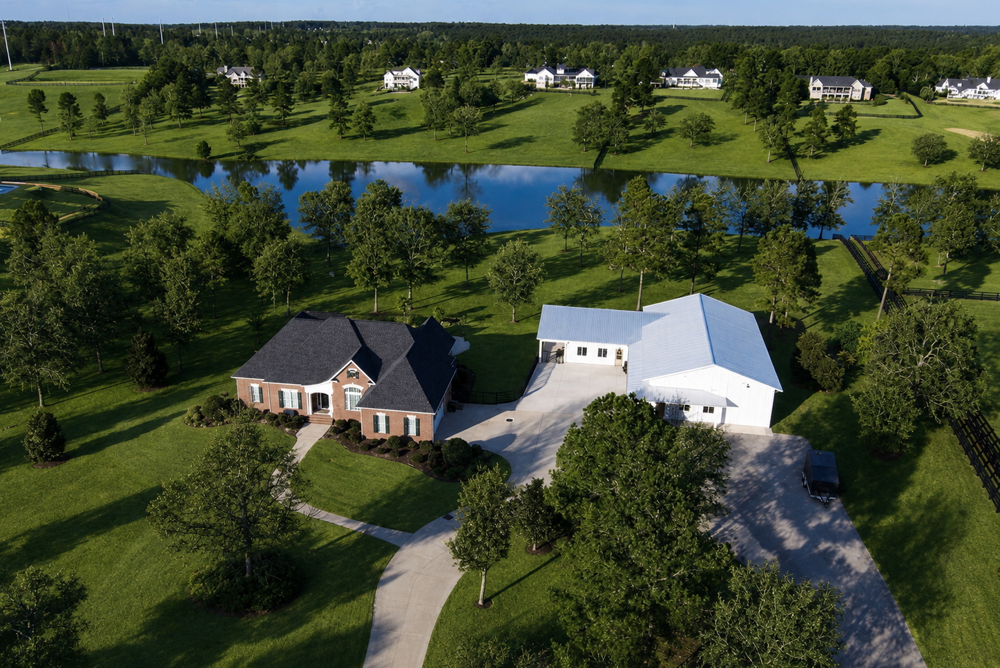 Aerial view of 764 Blue Roan Ct with pond, home, barn, and acreage
